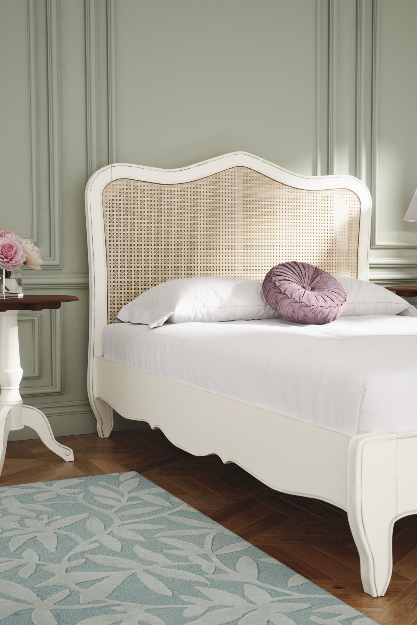 White bed with wicker headboard and decorative pillows in a bedroom setting.