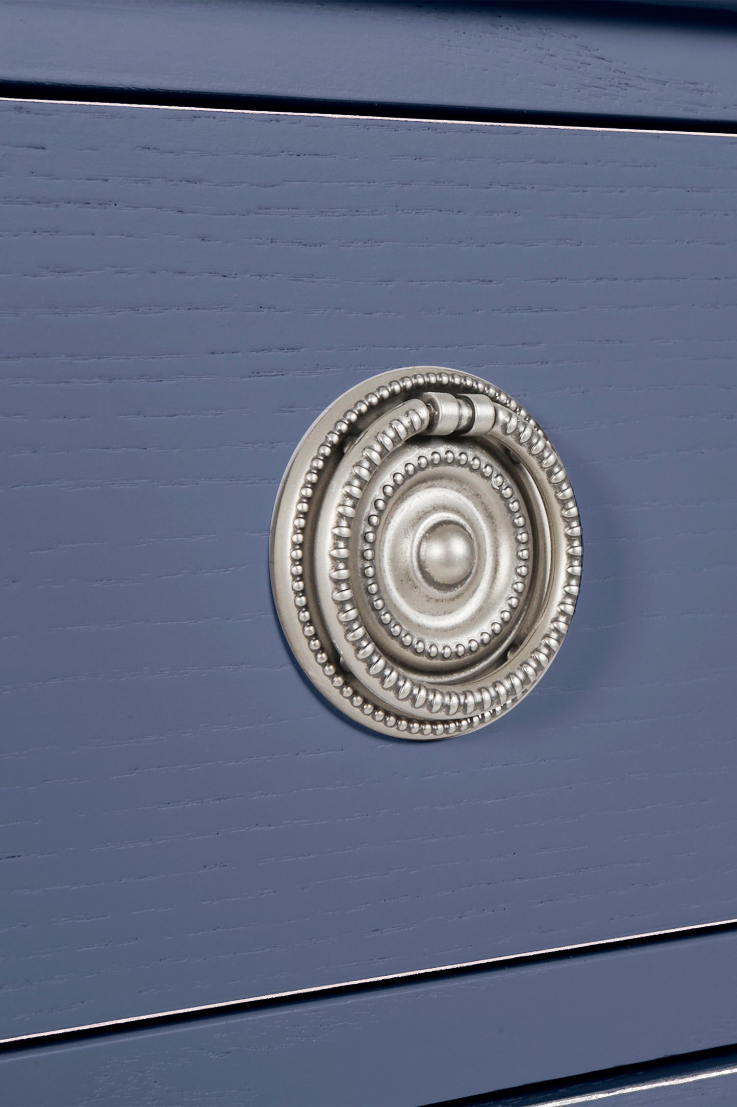 Close-up of a blue drawer with a decorative silver handle