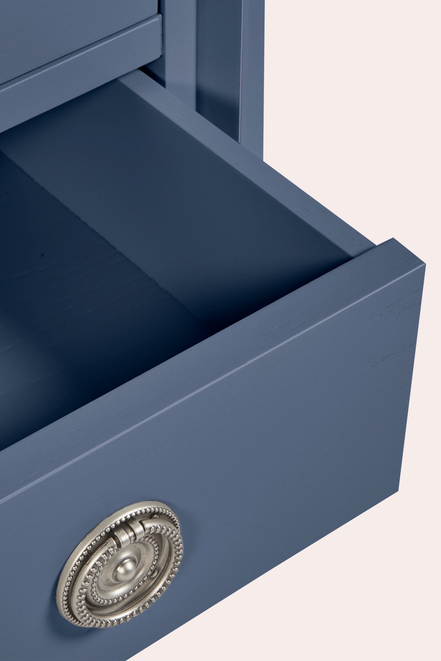 Blue drawer with decorative handle on a light beige background