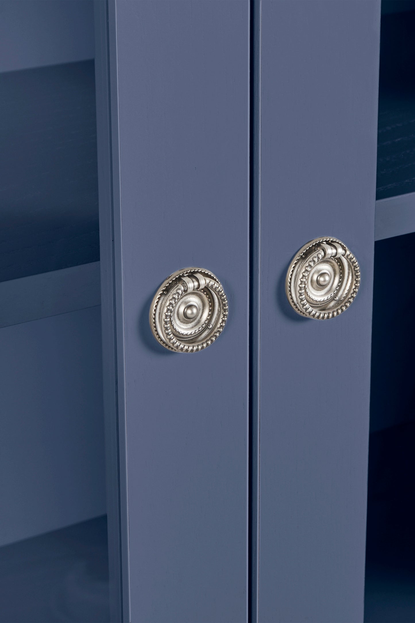 Close-up of a blue cabinet with decorative silver knobs.
