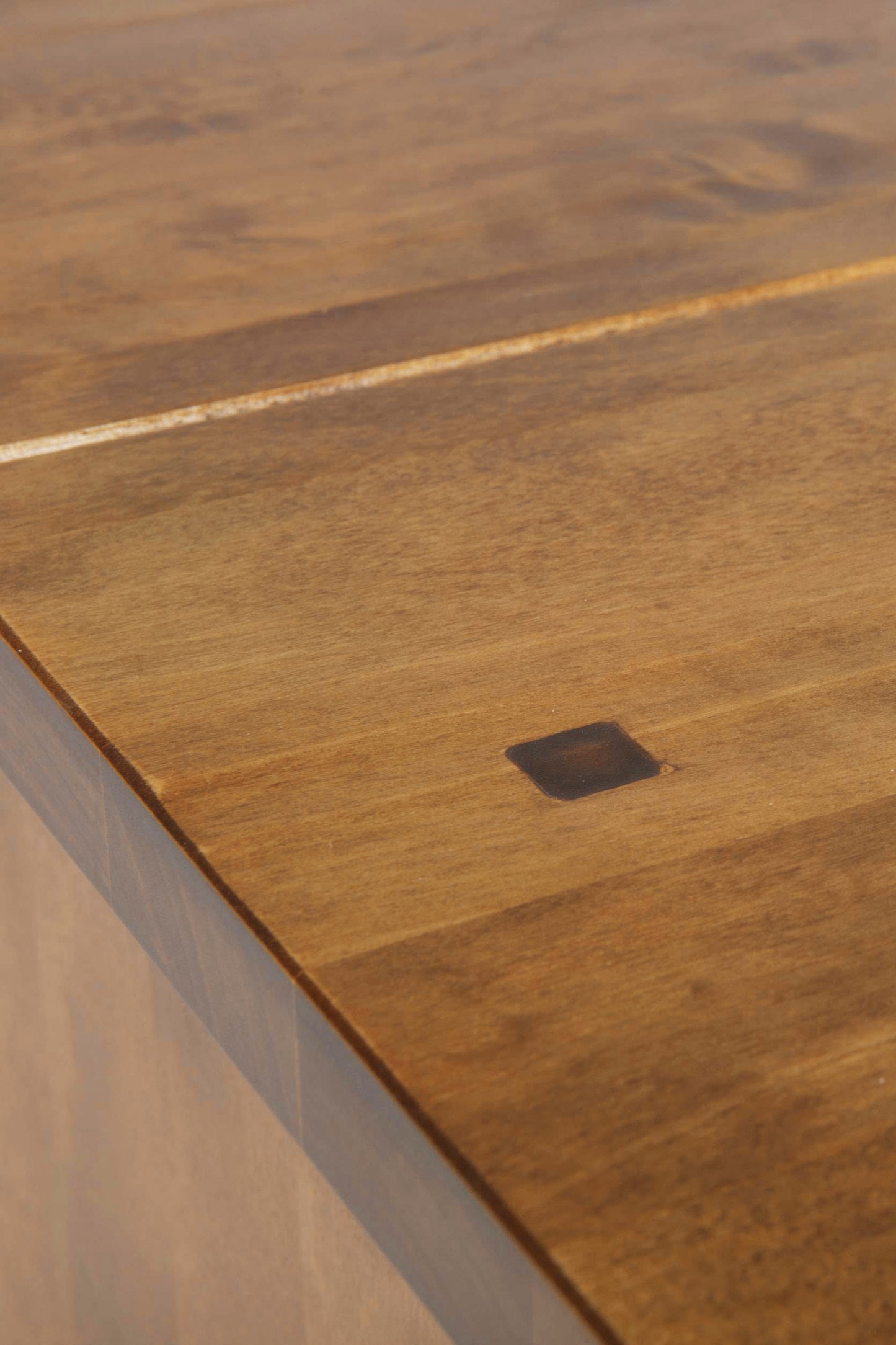Close-up of the corner of the laura Ashley Garrat 9 Drawer Coffee Table made of solid wood with a honey finish.