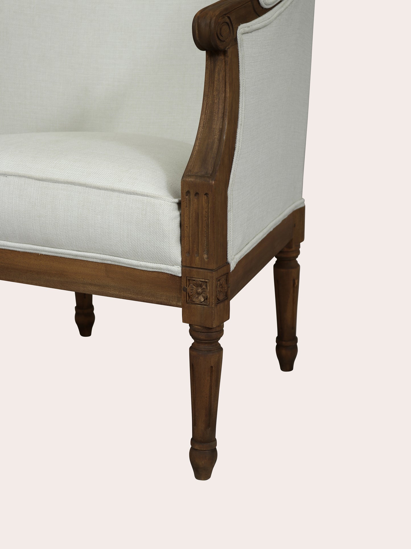 Chair with wooden frame and white cushion on a light pink background