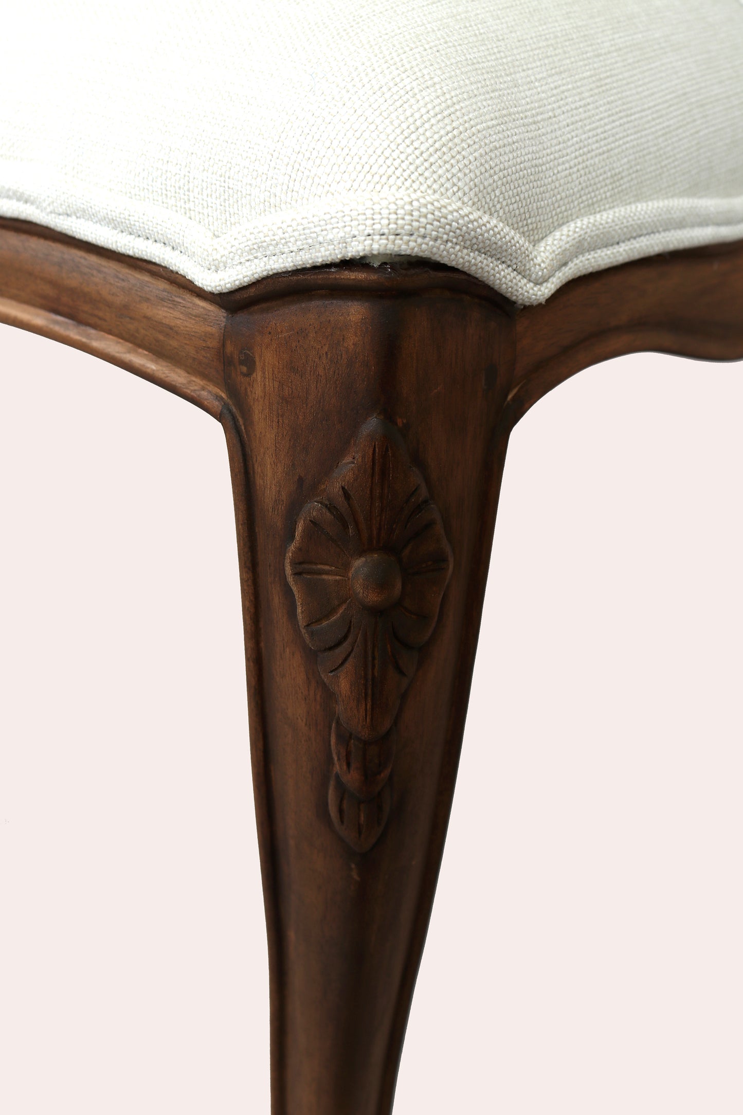Close-up of a wooden chair leg with intricate carvings on a white background