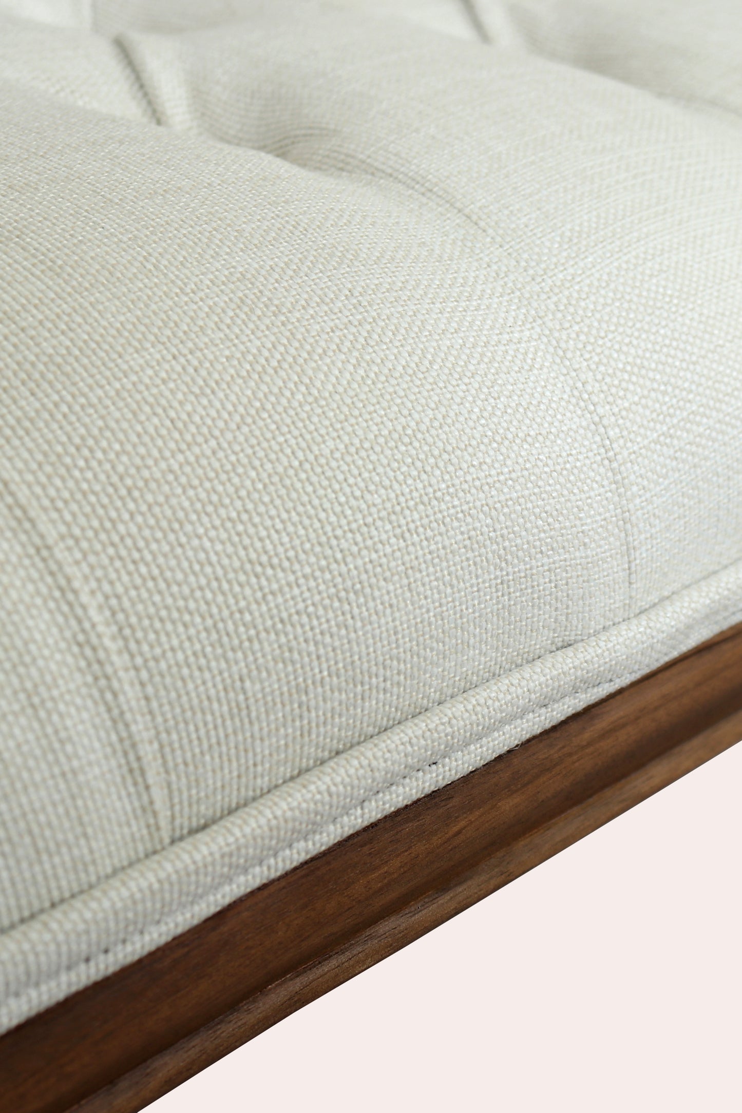 Close-up of a textured light gray cushion with a wooden border on a white background