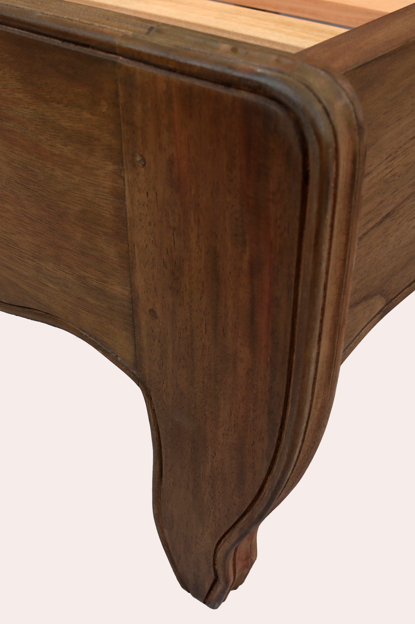 Close-up of a wooden table corner with a light wood top.