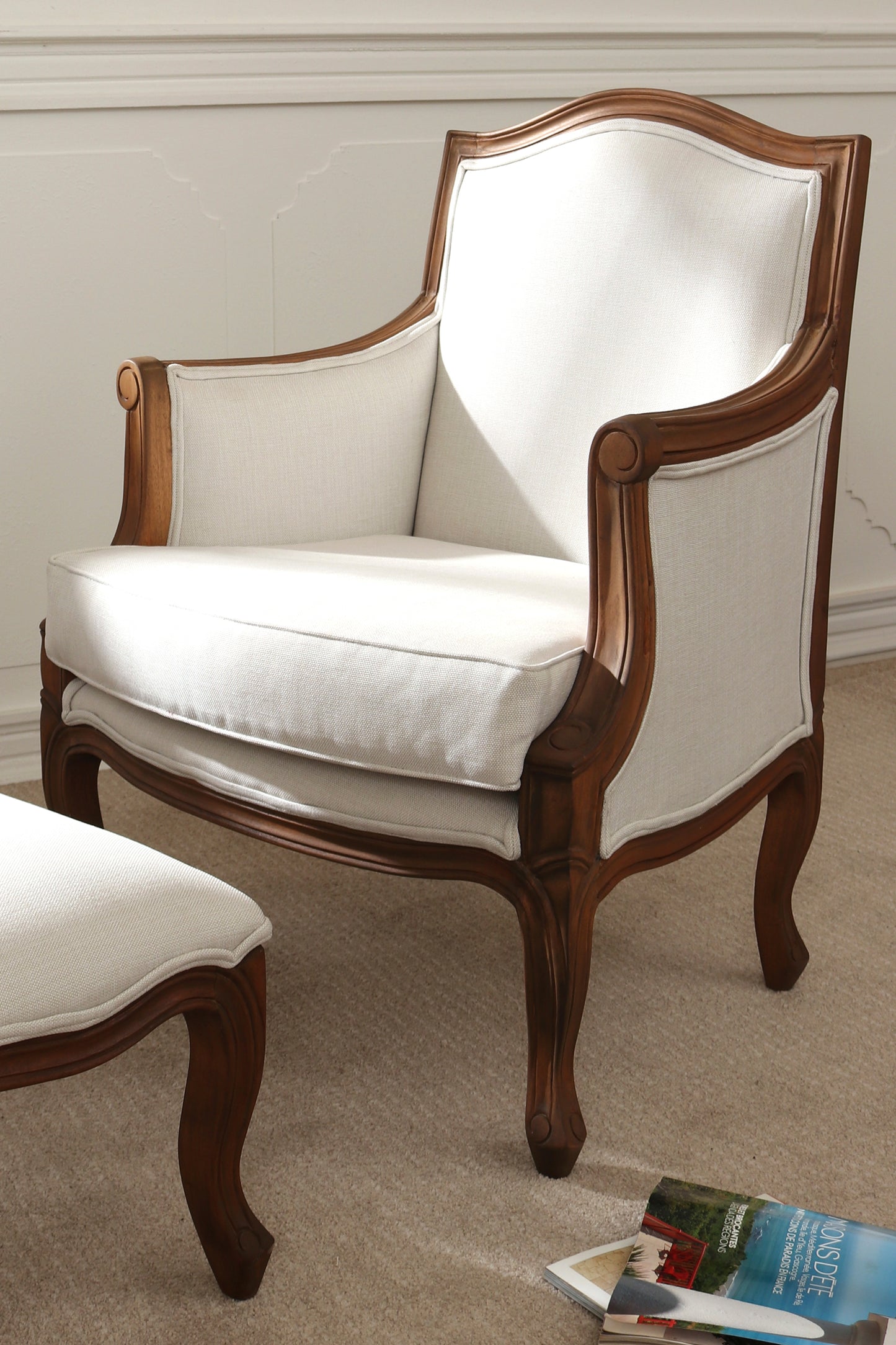 White upholstered armchair with wooden frame on a beige carpet