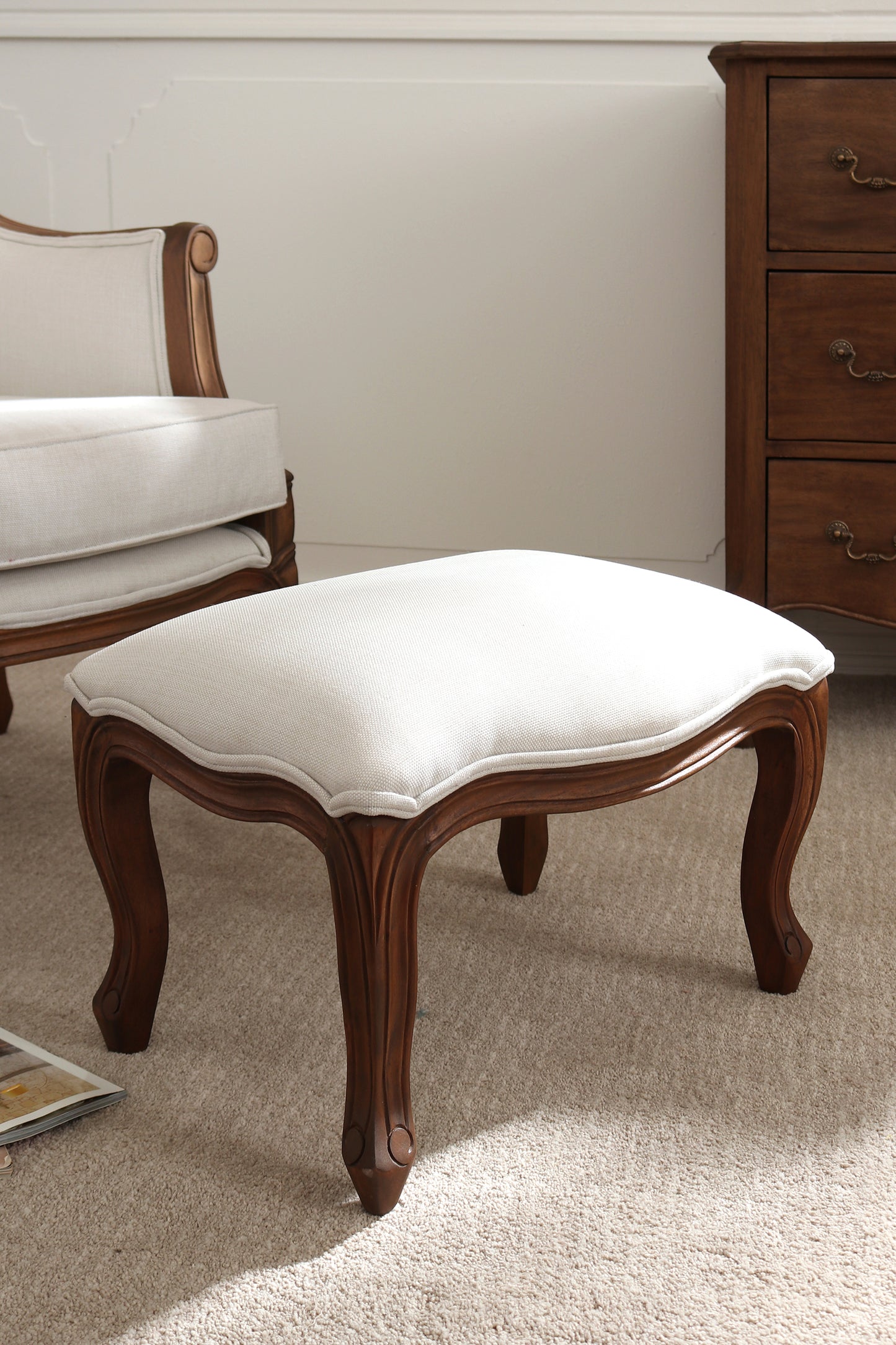 Wooden stool with white cushion in a room setting