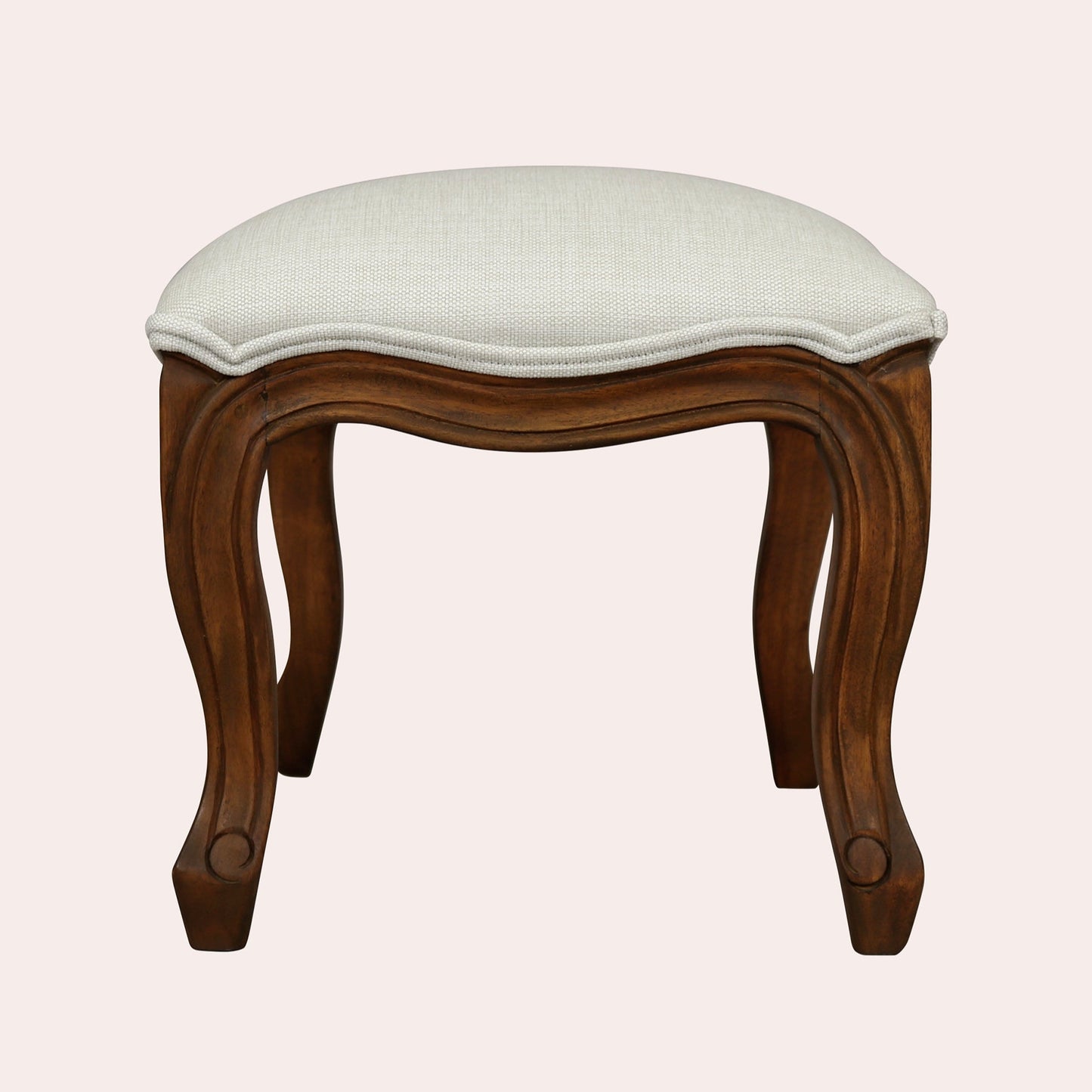 Wooden stool with a white cushion on a light pink background