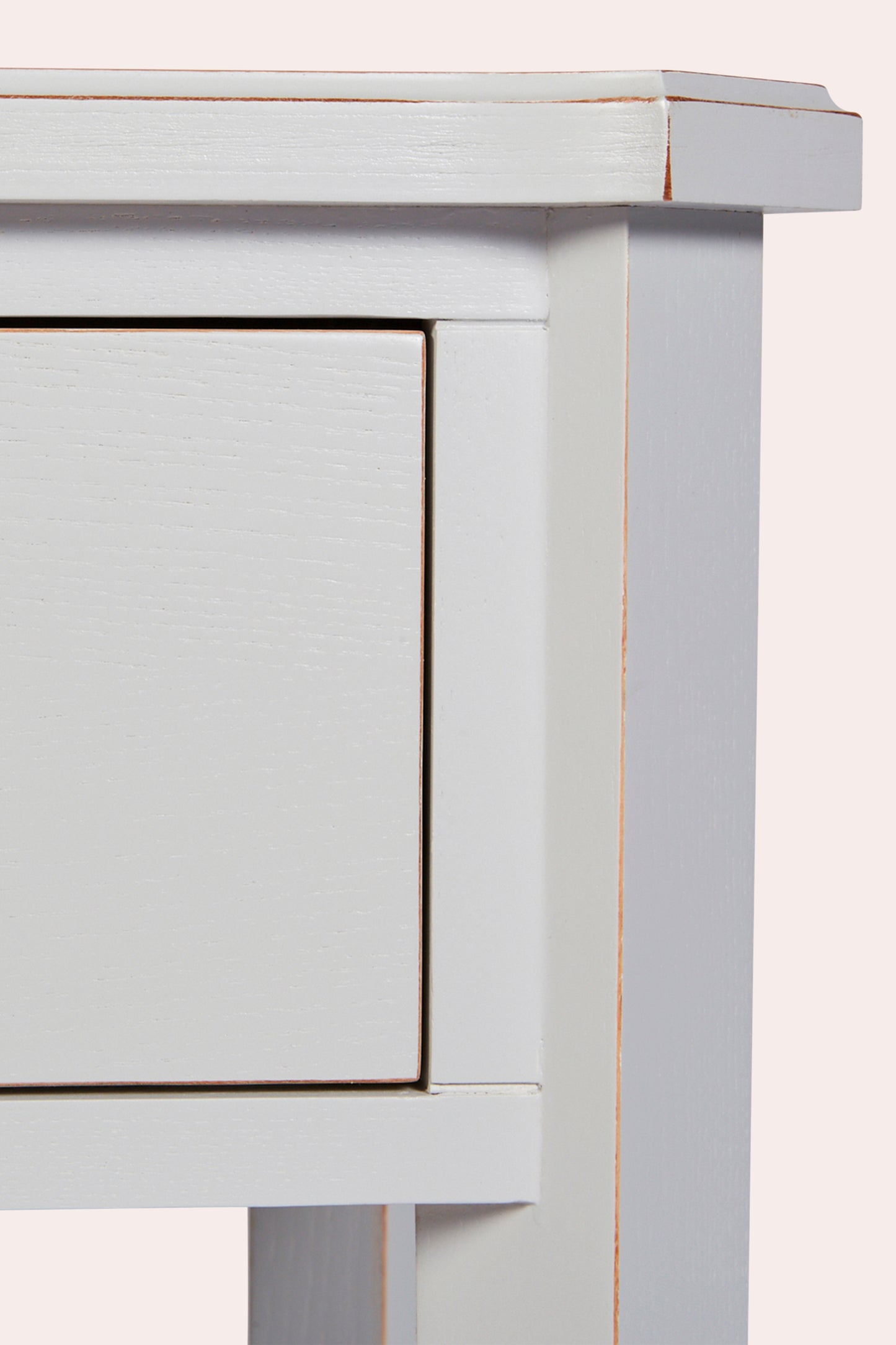 Close-up of a light gray wooden side table with a drawer.