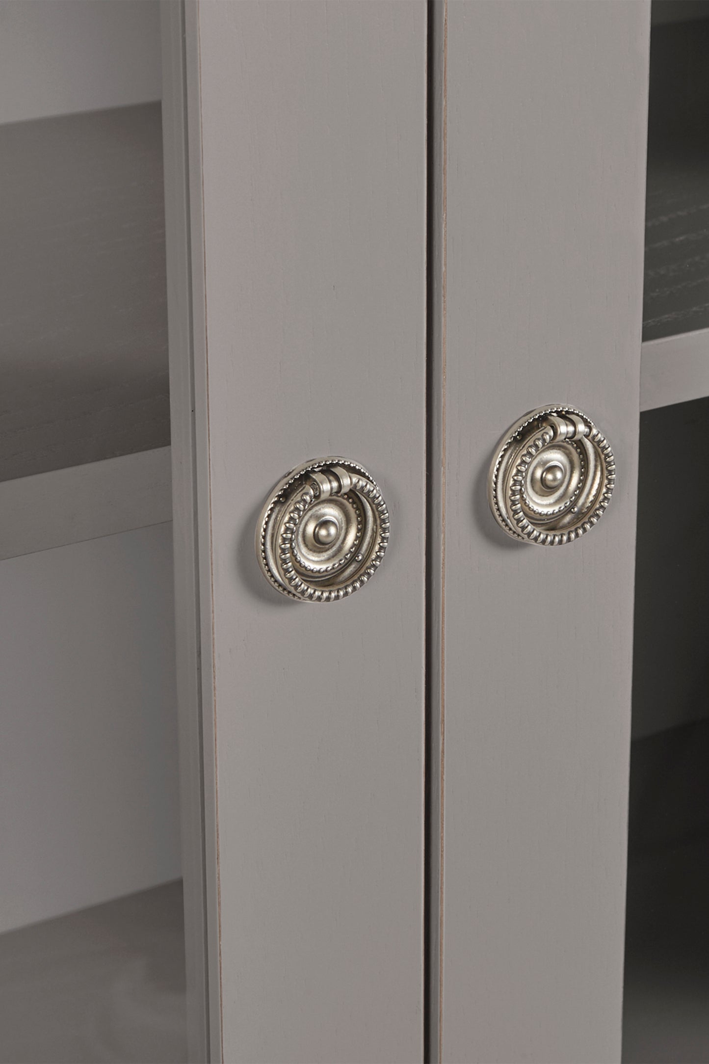 Close-up of a gray cabinet with decorative silver knobs.