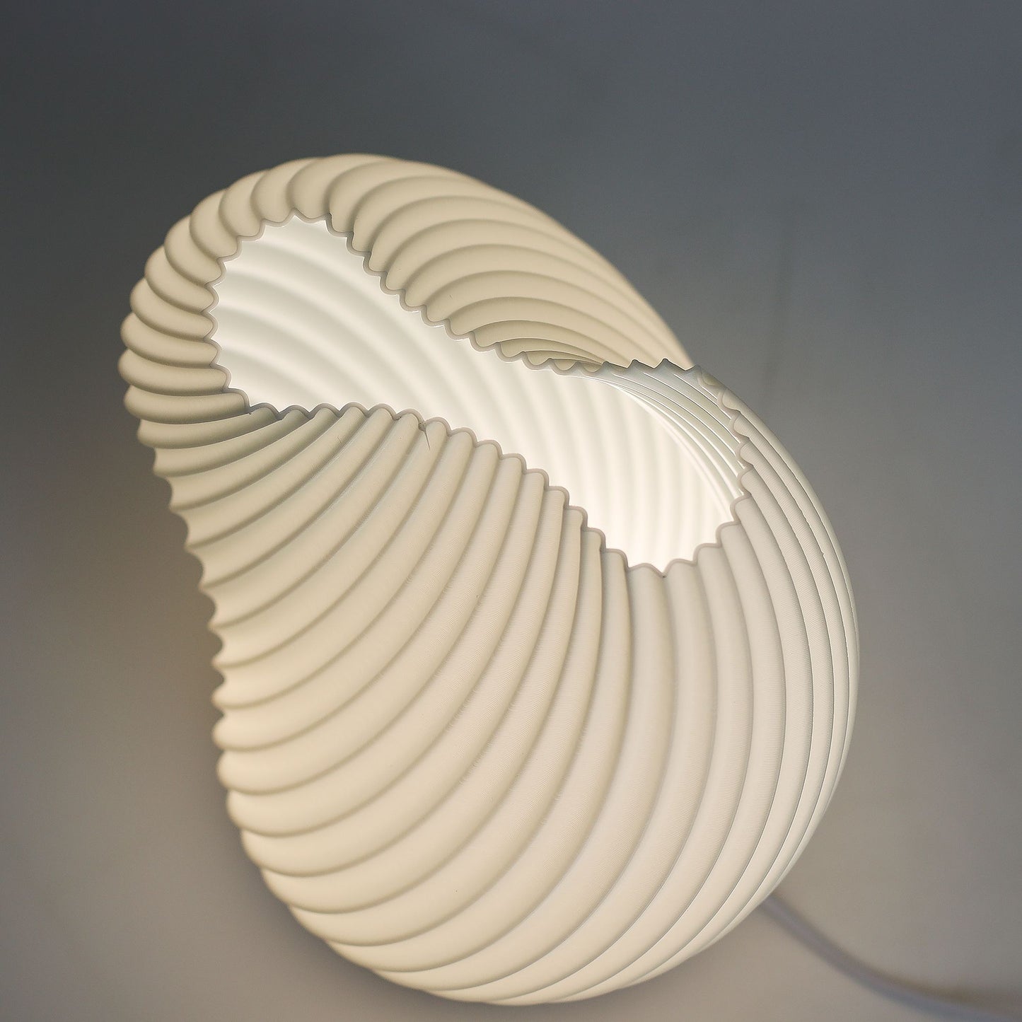 Modern table lamp with a shell-like design on a dark background