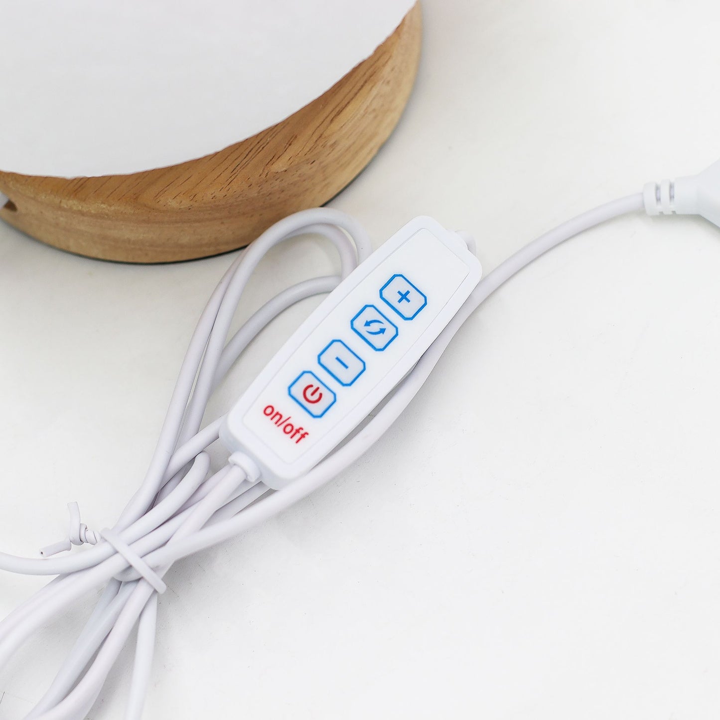 White table lamp cable with control panel featuring blue buttons and red 'on/off' label on a light background