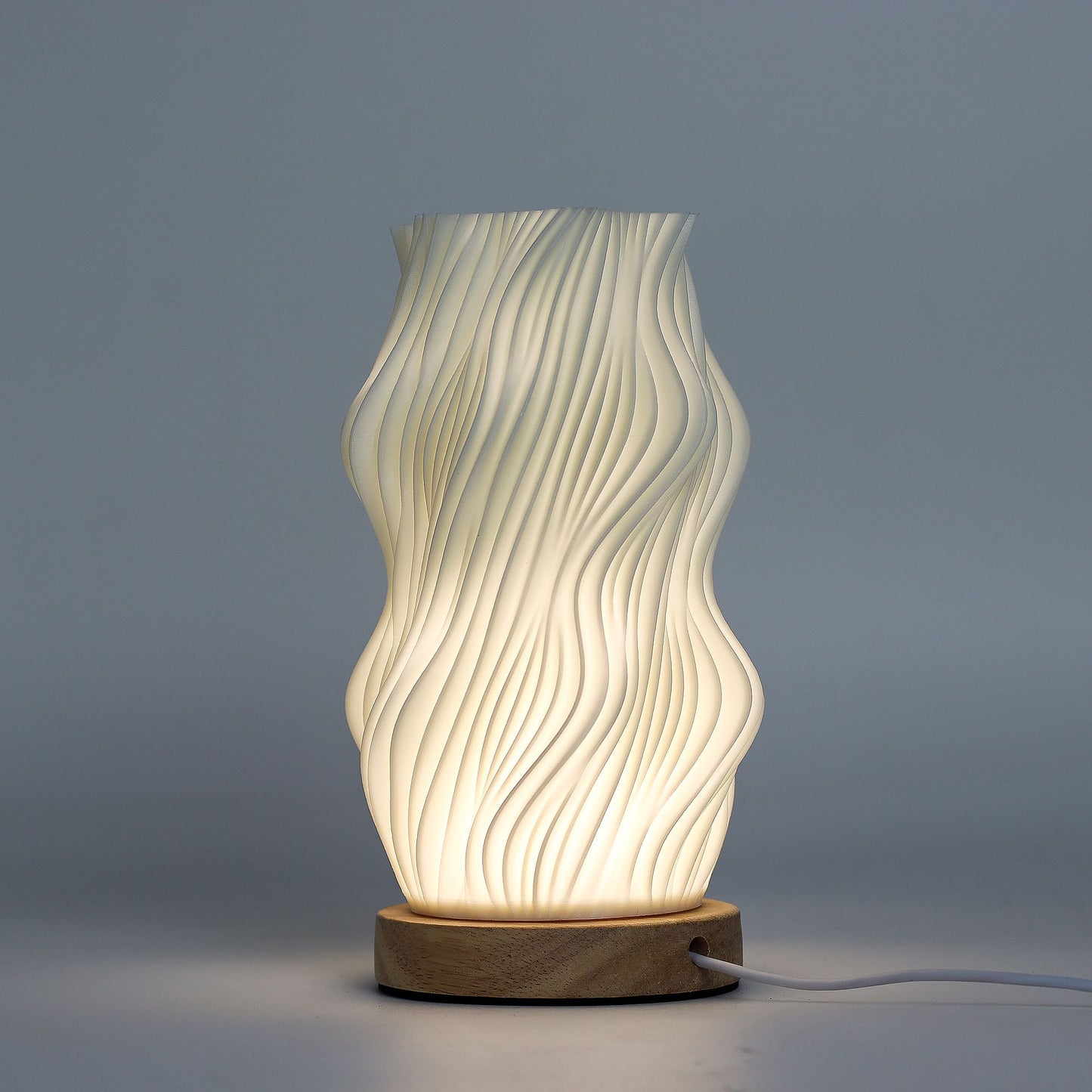Decorative table lamp with wavy design on a gray background