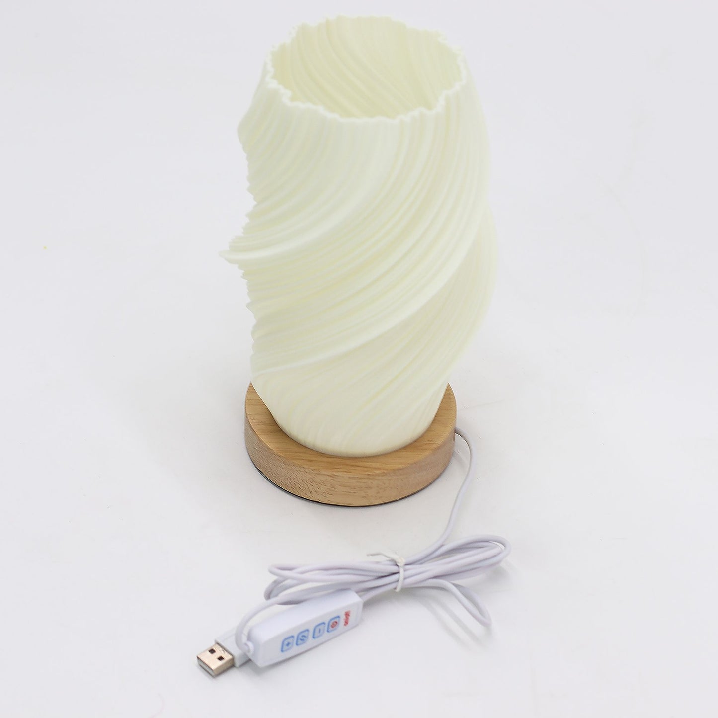 Cylindrical lamp with wavy design on a wooden base and USB cable on a white background