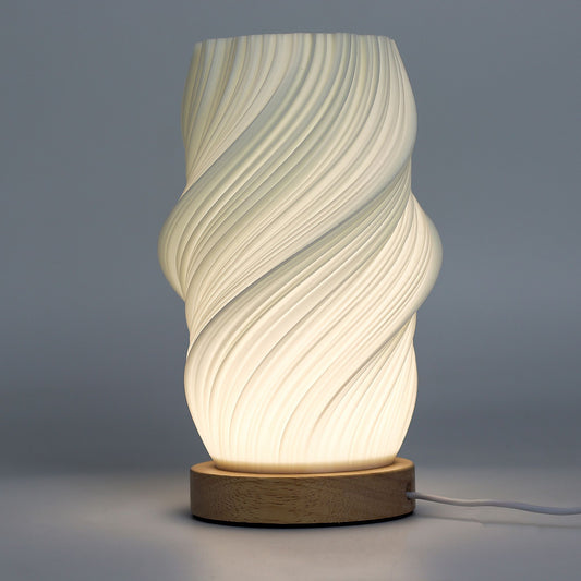 Decorative table lamp with wavy design and wooden base on a gray background