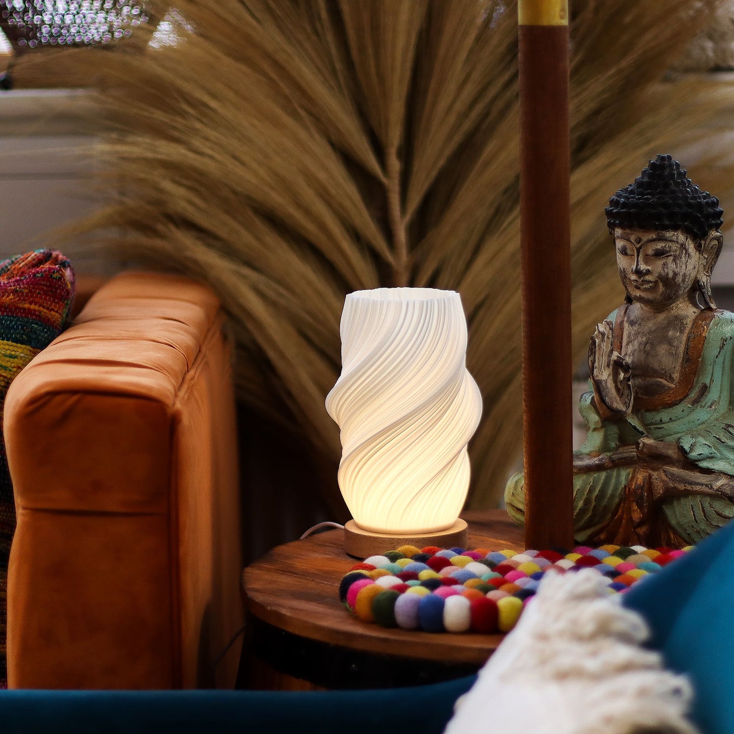 Decorative lamp on a table with a Buddha statue and colorful balls in a cozy room setting.