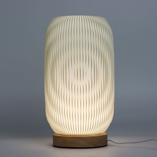 Textured table lamp with wooden base on a gray background