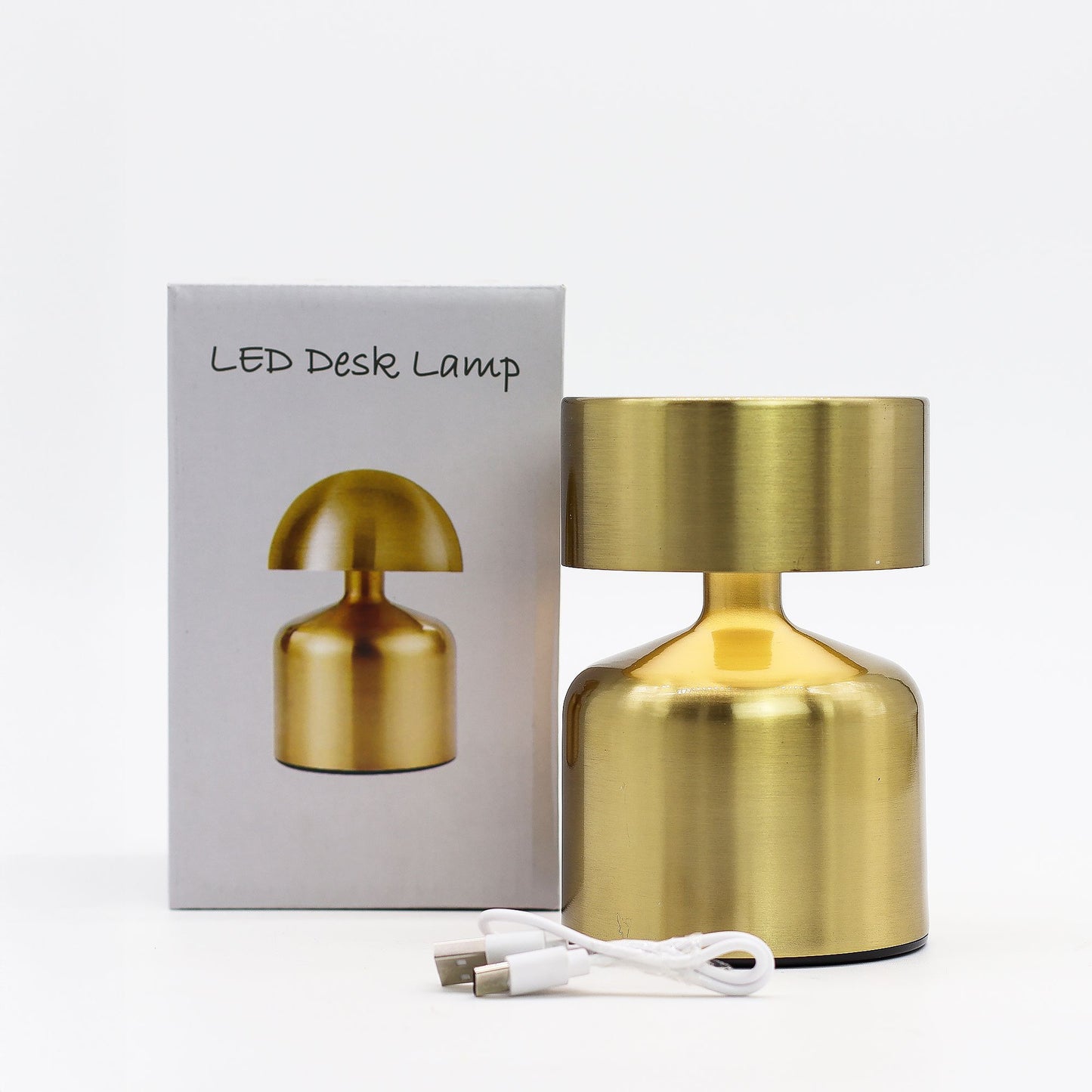Gold LED desk lamp with packaging and USB cable on a white background