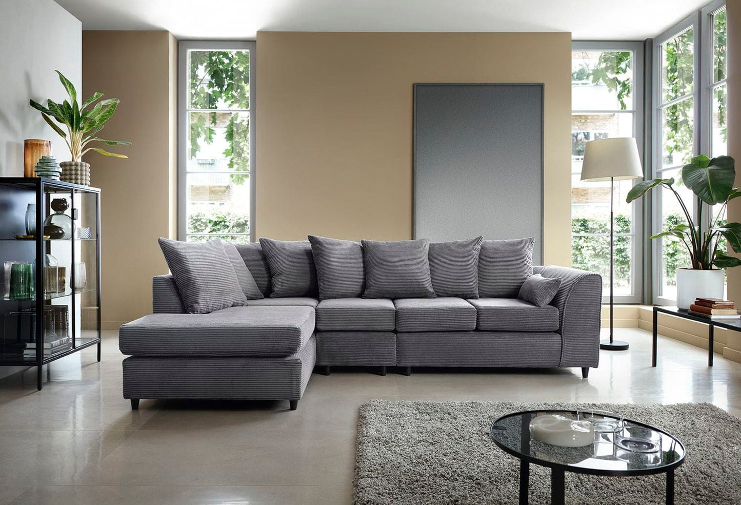 Gray sectional sofa in a modern living room with large windows and decor.