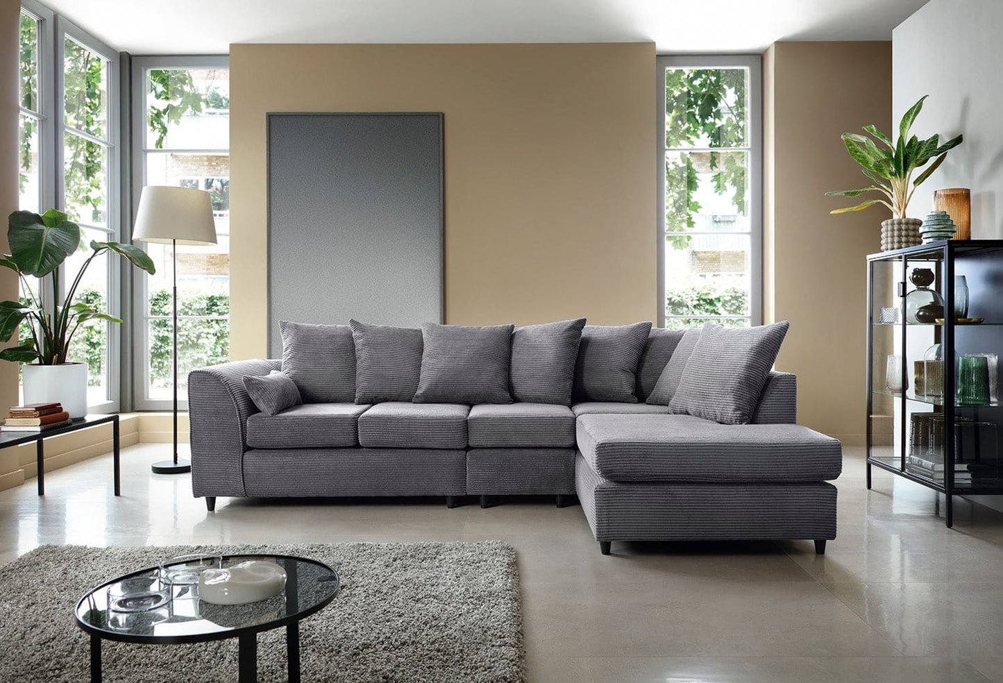 Gray sectional sofa in a modern living room with large windows and decor.