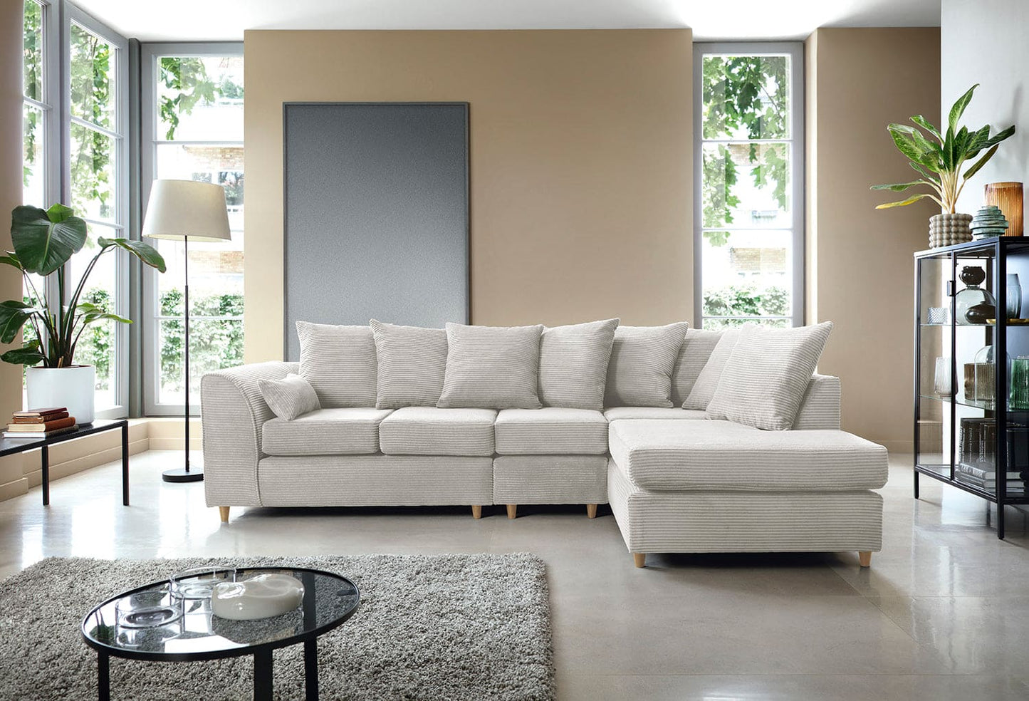Modern living room with a beige sectional sofa, coffee table, and decorative items.