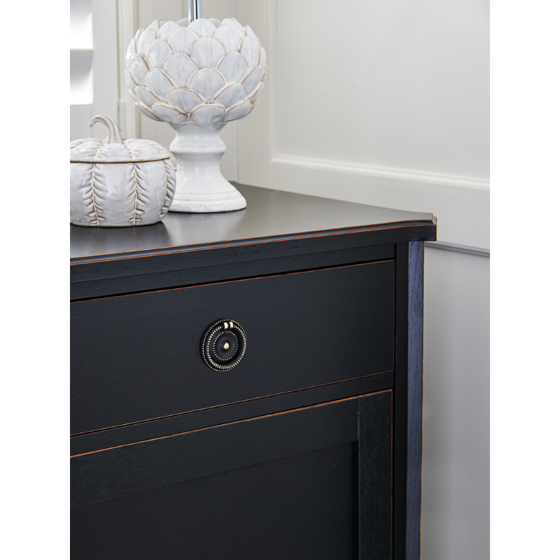 Dark wooden dresser with decorative items on top against a white wall