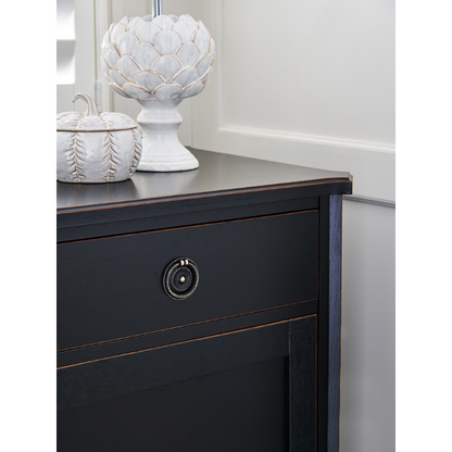 Dark wooden dresser with decorative items on top against a white wall