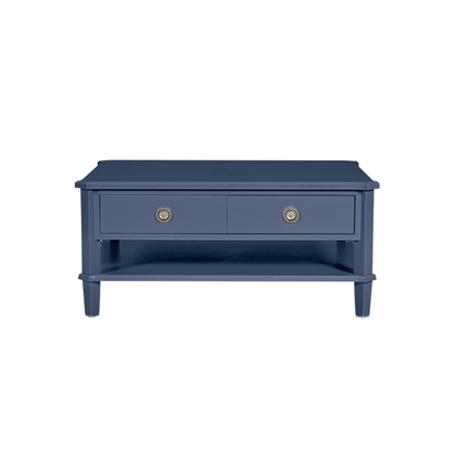 Navy blue coffee table with two drawers and brass handles on a white background