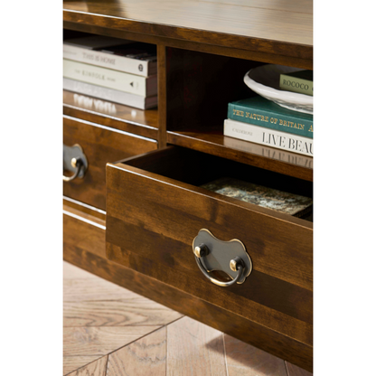 Close up of a wooden TV unit with open drawer and books on top.