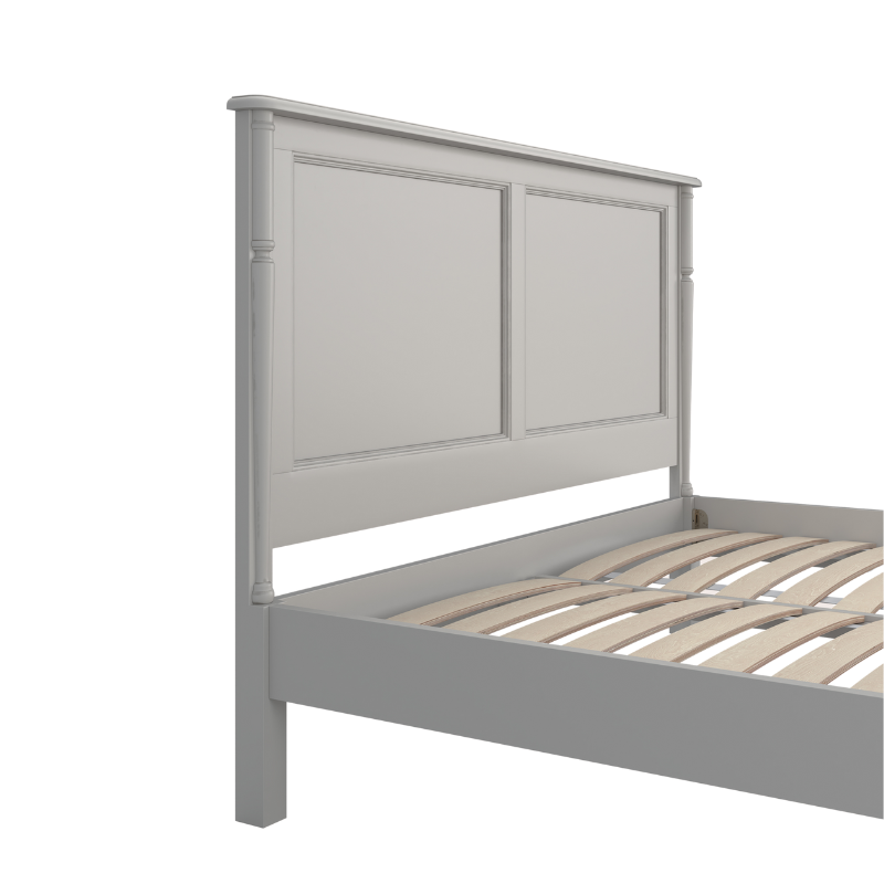 A left-hand angle close up of a Dove grey wooden headboard and bed frame  in a plain style with no visible bedding or additional accessories.