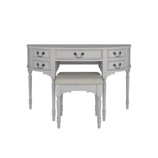 A Clifton Dove Grey 5 Drawer Dressing Table with a stool set in front of it. The table is large with multiple drawers and the stool is cushioned.
