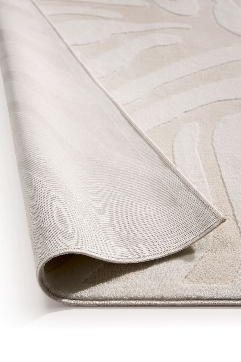 Close-up of a textured beige rug with subtle patterns on a white background