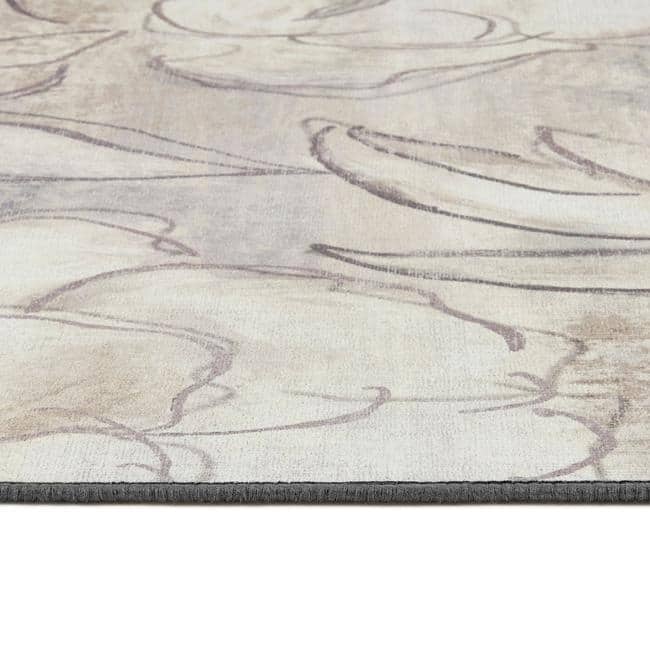 Close-up of a textured rug with wavy patterns in neutral colors.