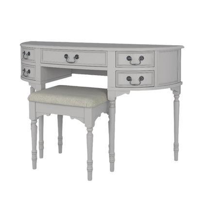 A right-hand corner view of the Clifton Dove Grey 5 Drawer Dressing Table with a stool set in front of it. The table is large with multiple drawers and the stool is cushioned.