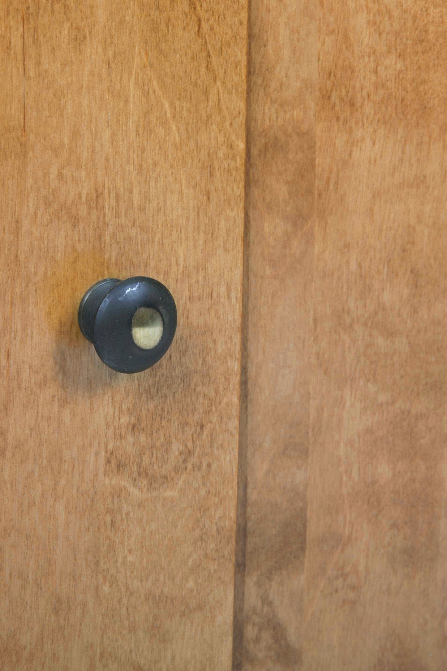 Close-up of a wooden door with a black knob.