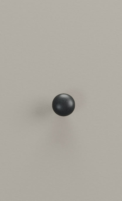 Black sphere on a pale french grey background