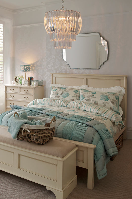 Bedroom with a bed, dresser, and chandelier.
