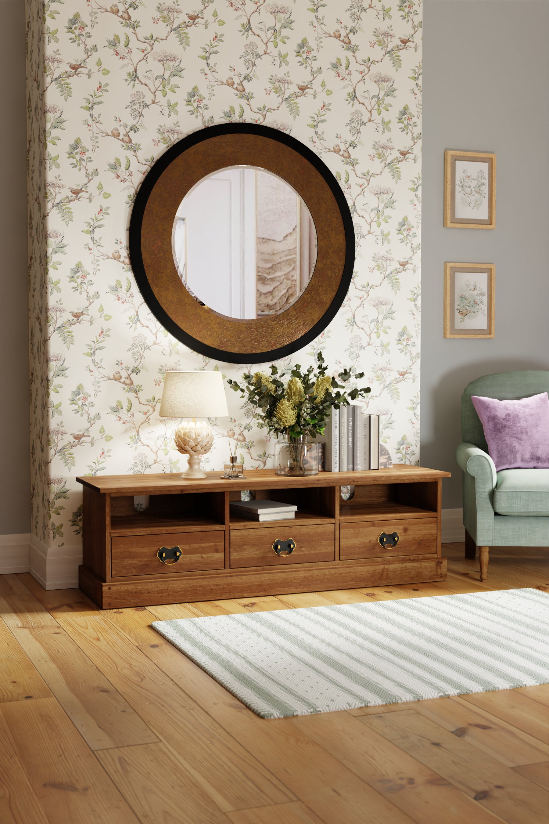 Wide wooden TV stand with round mirror and floral decorations in a living room.