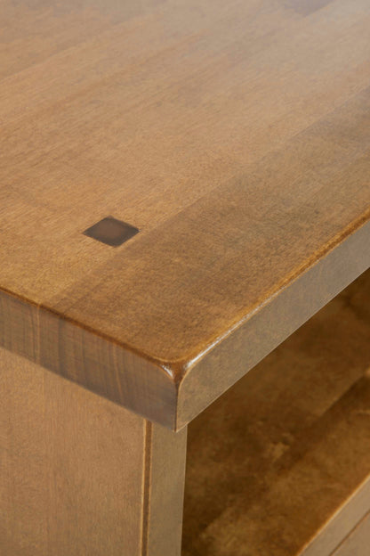 Close-up of a wooden table surface with a small square hole.