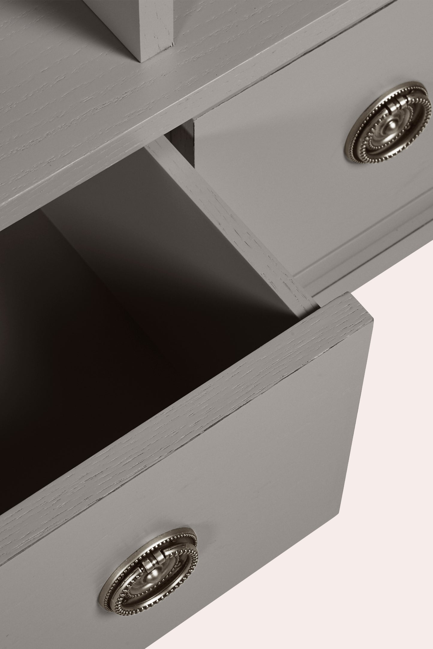 Close up of an open drawer and decorative knobs on a white background
