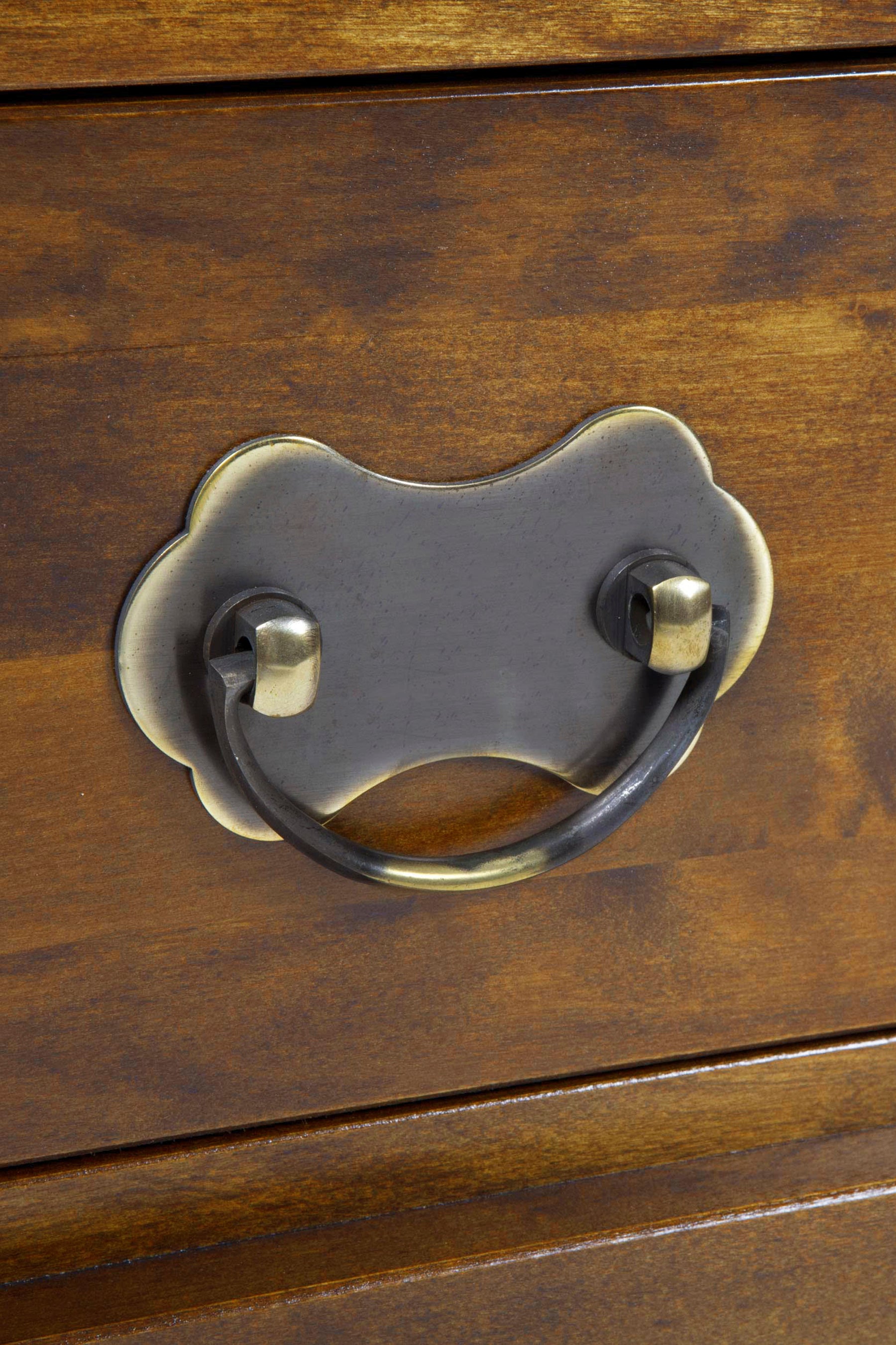 Close-up of a wooden drawer with a metal handle.