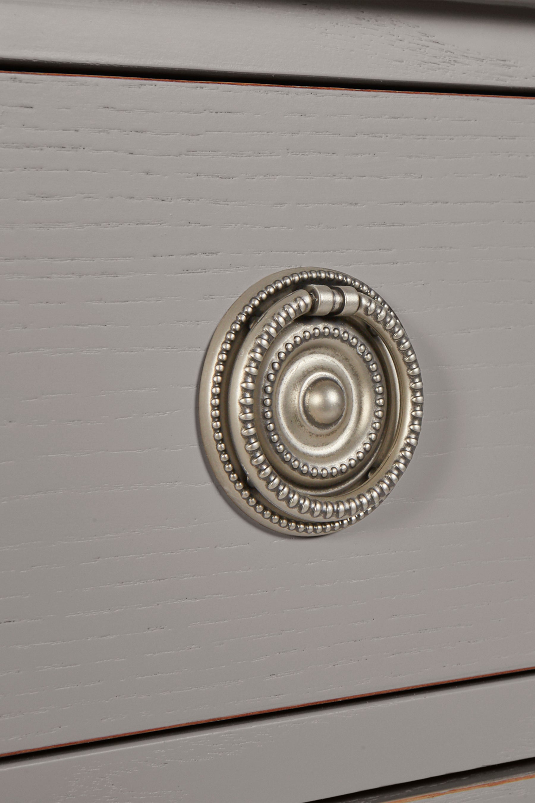 Decorative silver knob on a gray wooden surface