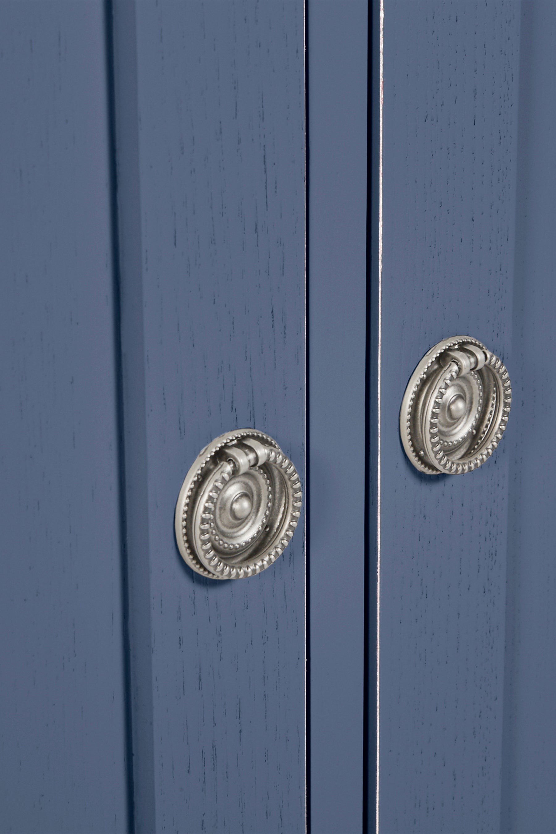 Close-up of a blue cabinet with decorative silver knobs