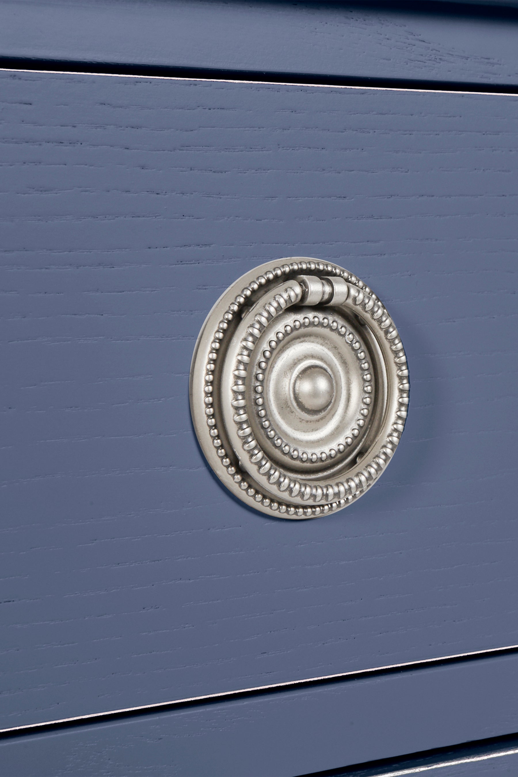 Close-up of a blue drawer with a decorative silver handle