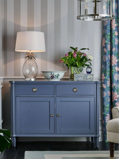Blue cabinet with decorative items against a striped wall
