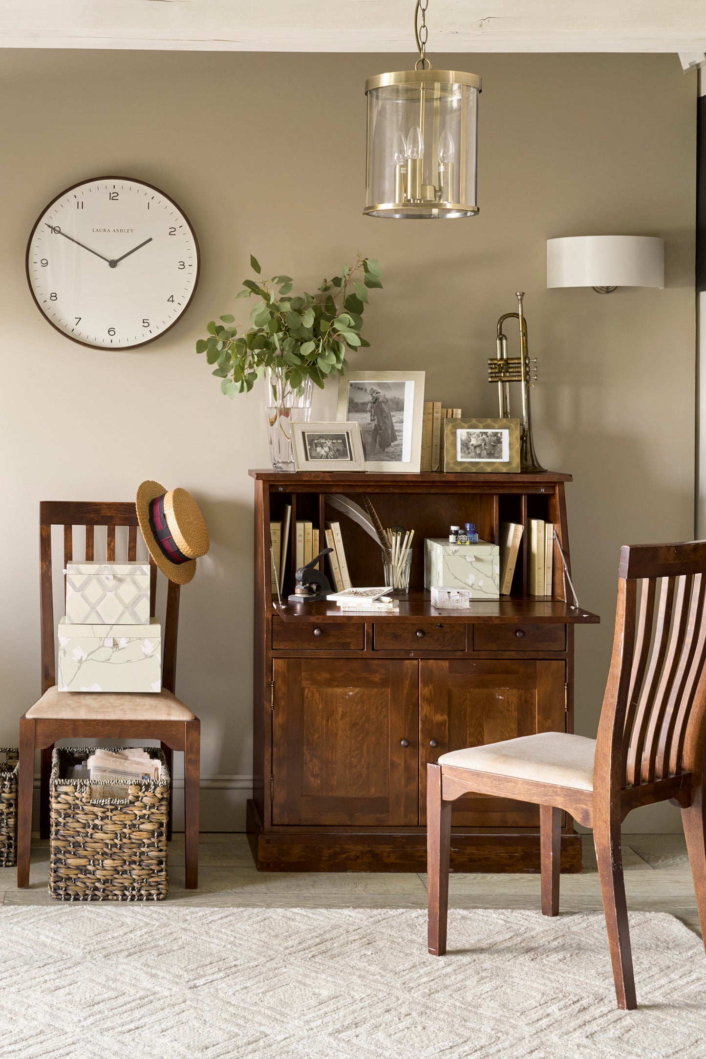 Small home office with wooden furniture and decorative items.