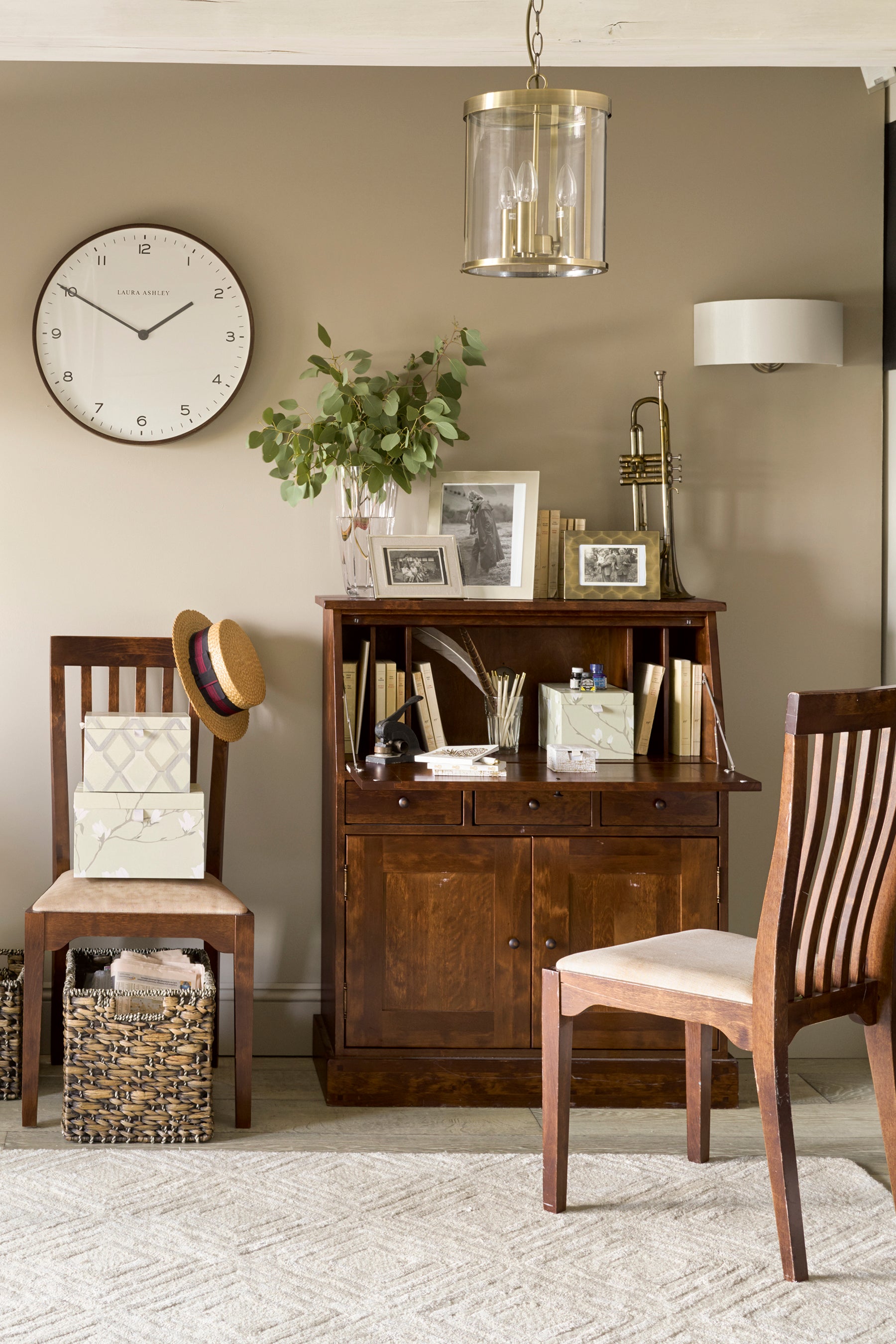 Small home office with wooden furniture and decorative items.