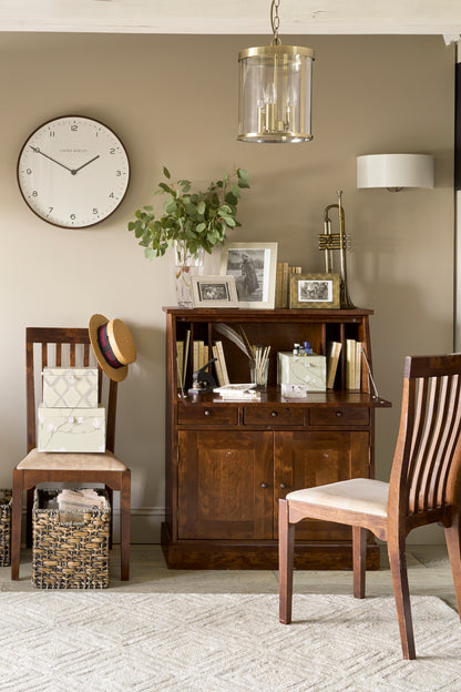 Small home office with wooden furniture and decorative items.