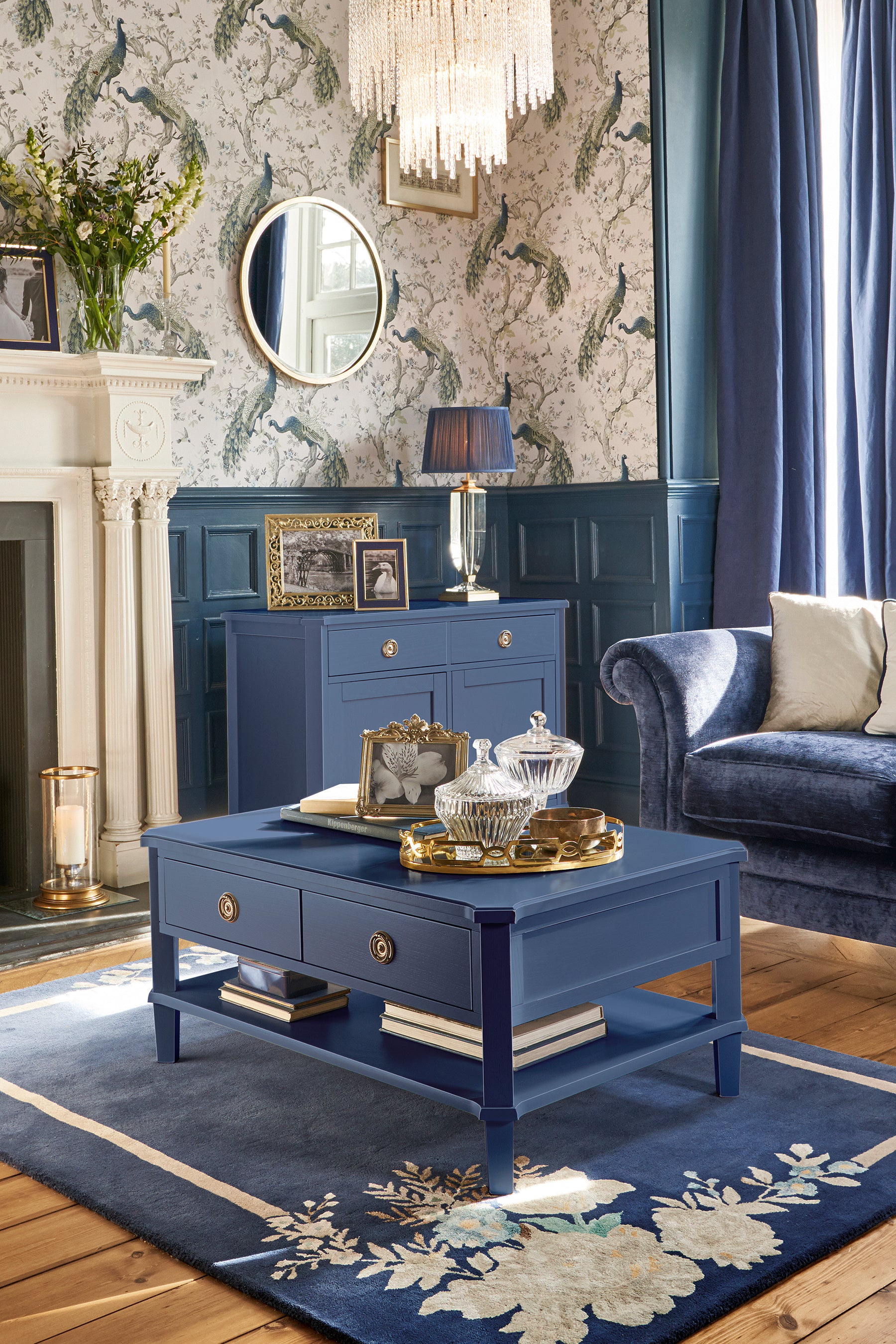 Living room with blue furniture, including a coffee table and sideboard, and decorative elements.