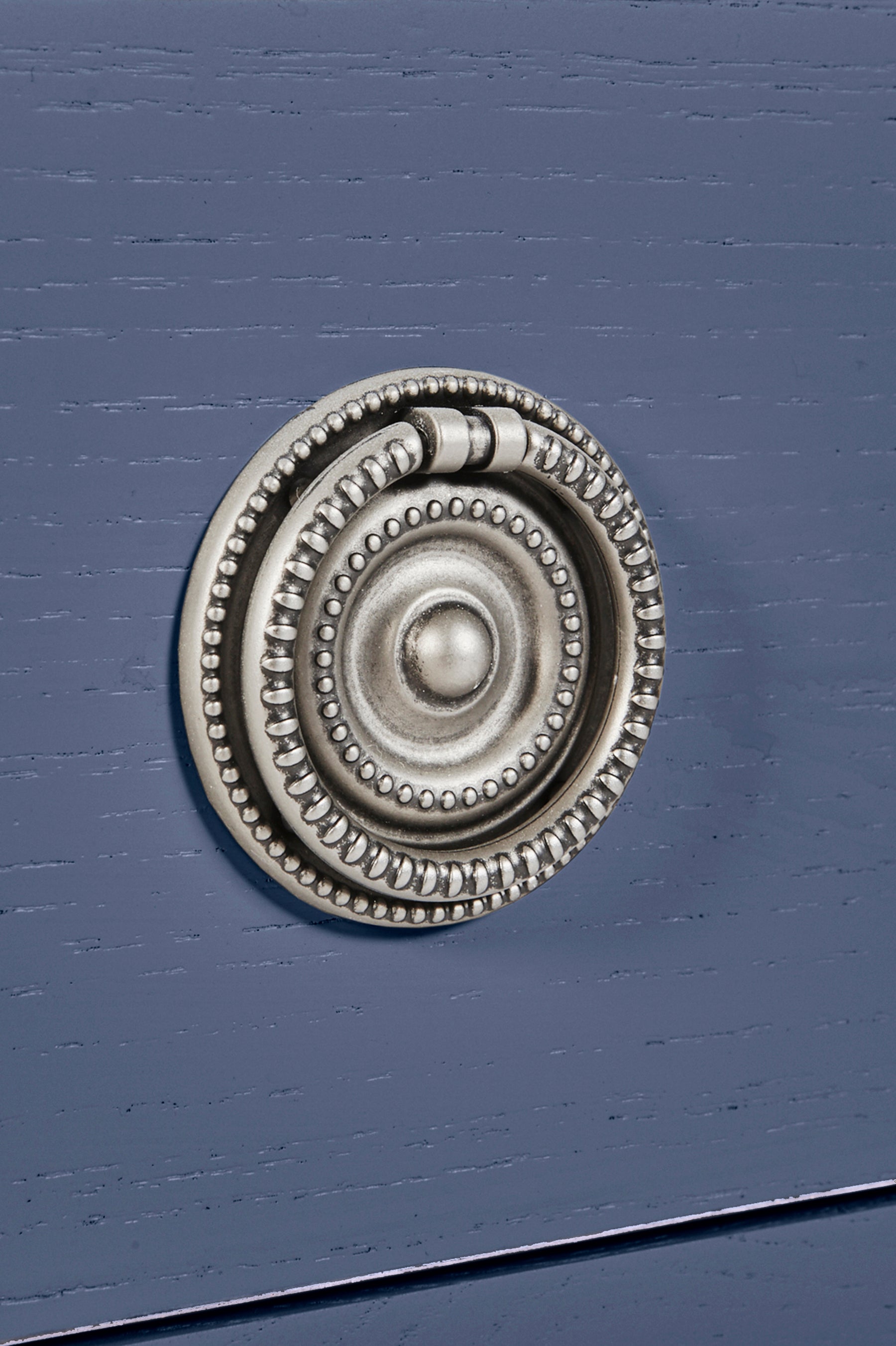 Decorative metal knob on a blue cabinet door